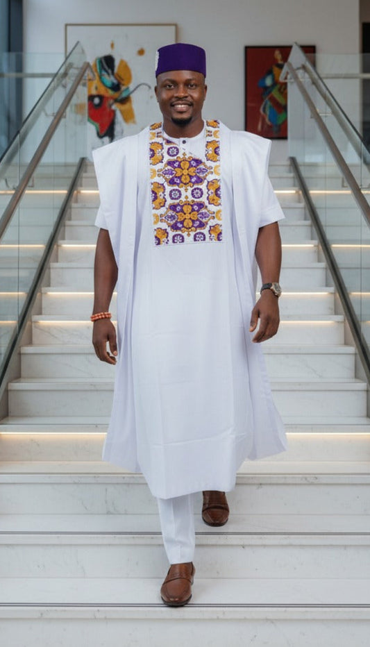 Man in traditional attire standing on a staircase in a modern building