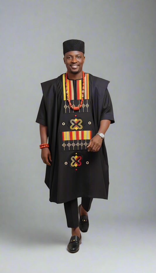 Man wearing a traditional black outfit with colorful patterns and accessories on a beige background